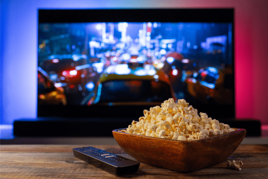 Wooden Bowl Filled with Popcorn beside the TV Remote