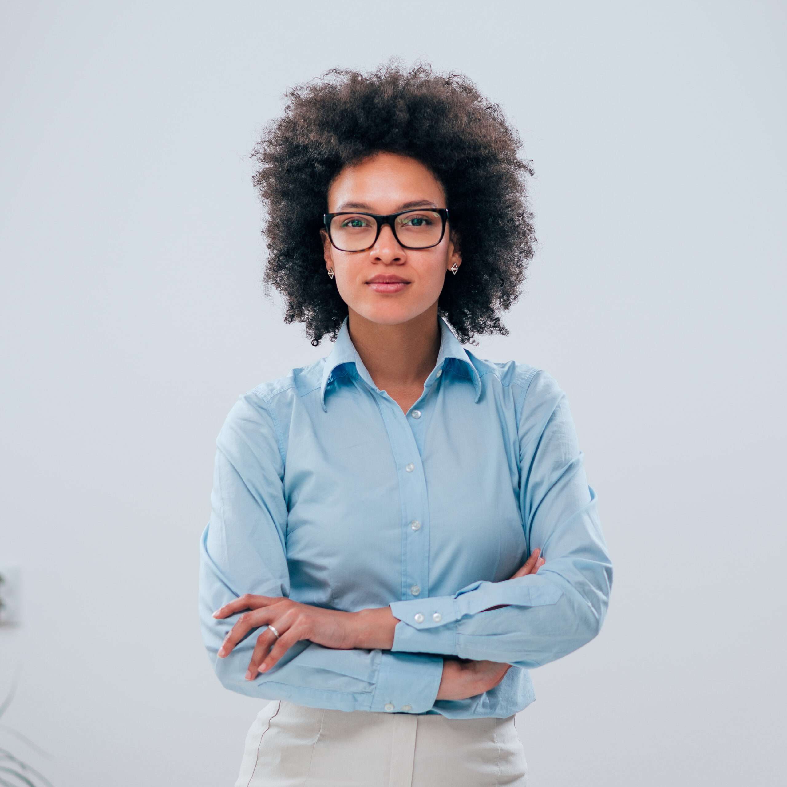 Portrait of a confident businesswoman with curly hair on isolated background.